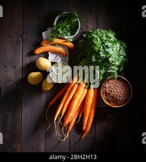 Bouquet de carottes, saucisses, persil, pommes de terre, soupe de lentilles en conserve et bol de lentilles Banque D'Images