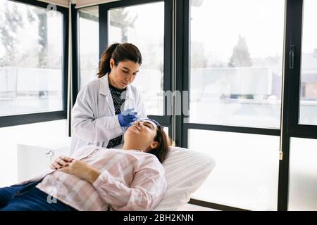 Femme recevant une injection de botox dans la pratique médicale Banque D'Images