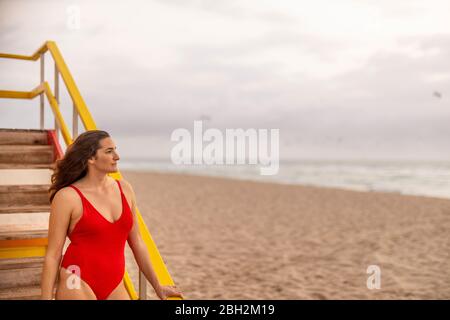 Femme en maillot de bain rouge à la hutte du maître-nageur sur Miami Beach, Miami, Floride, États-Unis Banque D'Images