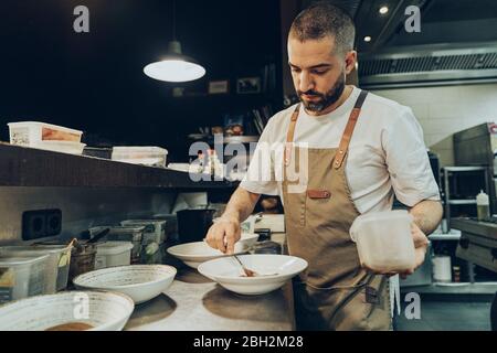 Chef s'occupant de plats sur les assiettes avant de servir au restaurant Banque D'Images