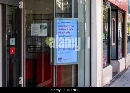 Les enseignes des fenêtres de la boutique conseillent les clients sur les procédures de la couverture-19 de Coronavirus Banque D'Images