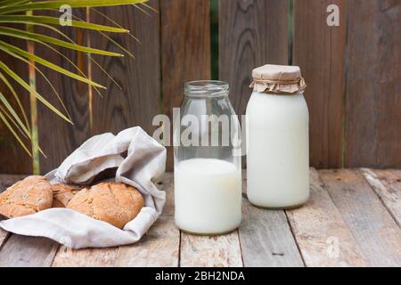 Lait biologique frais en bouteille de verre sur table rustique en bois sur fond de nature. Concept de saine alimentation Banque D'Images