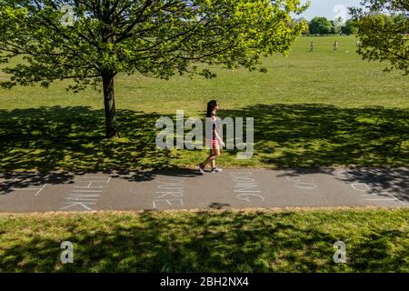 Londres, Royaume-Uni. 23 avril 2020. Les gens font passer un message positif - je pense que vous le faites si bien, considérant - écrit dans la craie sur la piste de cycle - Clapham Common est raisonnablement occupé car le soleil est dehors et il est plus chaud. Le « verrouillage » se poursuit pour l'épidémie de Coronavirus (Covid 19) à Londres. Crédit: Guy Bell/Alay Live News Banque D'Images