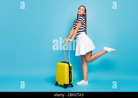 Photo pleine de profil de corps de belle dame voyageur flirty envoyer air kisses roulement valise été voyage porter t-shirt rayé blanc jupe courte Banque D'Images