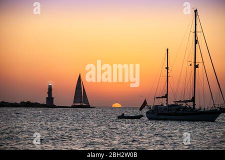 Ciel rouge dans un coucher de soleil sur la mer, les silhouettes d'un phare et voiliers. Formentera Island, Espagne, voyage, concept de vacances Banque D'Images