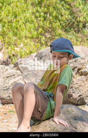 Les garçons étaient en train de jouer sur les rochers et profitez de l'Kra-Din Chok chutes d'eau à Kanchanaburi en Thaïlande Banque D'Images