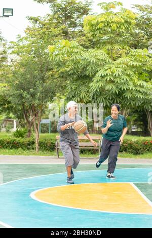 Un vieil homme et une femme jouent au basket-ball le matin, si heureux au BangYai Park Nonthaburi en Thaïlande. 22 août 2018 Banque D'Images