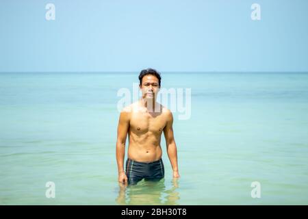 Les hommes asiatiques nageant dans la mer. Banque D'Images