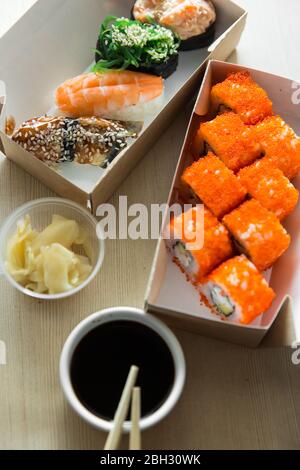 De beaux petits pains et sushis et un rouleau californien sur une table blanche. Livraison de nourriture. Déjeuner. La nourriture à la maison. Banque D'Images