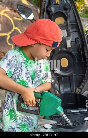 Asian boy du remplissage du carburant dans la moto Banque D'Images