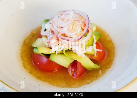 Salade fraîche avec de la viande de crabe et de l'avocat dans une assiette. Banque D'Images