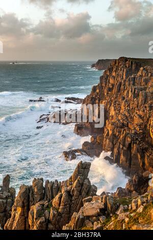 Depuis près de Gwennap Head à la recherche vers le phare de Drakkars et Land's End ; jour venteux en hiver les vagues fouetter ; Cornwall Banque D'Images