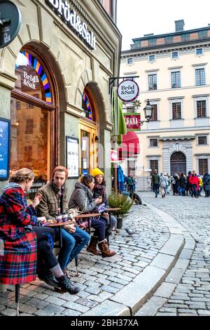 Les personnes assises à l'extérieur d'un café en hiver à Gamla Stan (vieille ville), Stockholm, Suède Banque D'Images