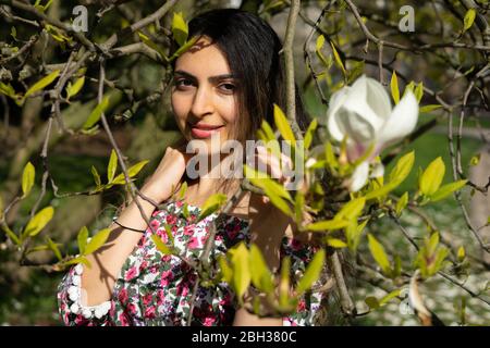 Modèle de femme d'âge moyen du Moyen-Orient posant au printemps avec un chemisier de fleurs autour d'un parc à Brême. Banque D'Images