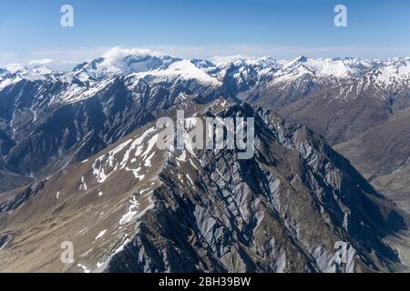 Aérien, à partir d'un planeur, de pentes abruptes sombres de Seton Peak , tourné dans une lumière de printemps vive du sud, Otago, île du Sud, Nouvelle-Zélande Banque D'Images