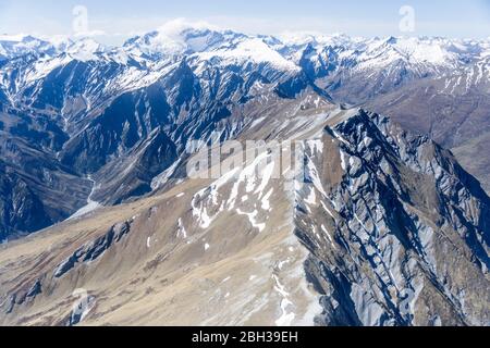 Aérien, à partir d'un planeur, d'un sommet sombre et abrupt de Seton Peak , tourné dans une lumière de printemps vive du sud, Otago, île du Sud, Nouvelle-Zélande Banque D'Images