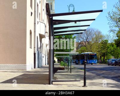 abri de bus sur la rue urbaine. structure en verre et aluminium. rue de la ville avec arbres. design en verre de sécurité. affiche et affichage publicitaire. bannière et espace de copie Banque D'Images