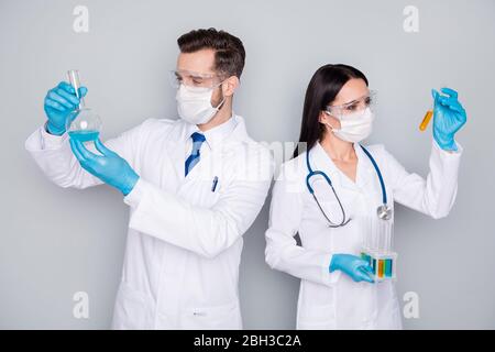 Photo de spécialistes doc gars dame clinique de virologie les médecins expérimentés détiennent la sonde de sang expérience chimique infection vaccin porter protéger les gants de masque Banque D'Images