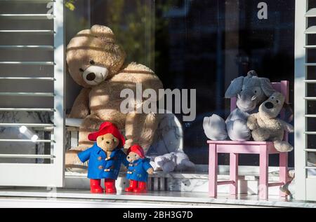 Ours en peluche placés dans la fenêtre d'une maison pendant l'éclosion de coronavirus (Covid-19) dans le cadre d'un jeu pour aider à distraire les enfants sous verrouillage Banque D'Images