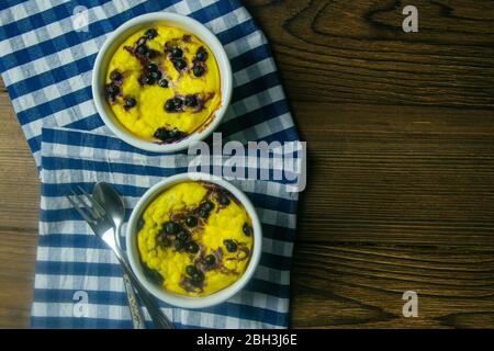 Cocotte au fromage cottage avec chocolat et bleuets dans une assiette blanche sur une table en bois. Vues de dessus avec espace libre Banque D'Images