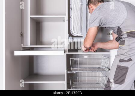 Le handyman assemble une salle de bains et une aire de rangement. Banque D'Images