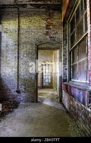 Porte-à-fenêtre et fenêtre en brique dans un hôpital abandonné Banque D'Images