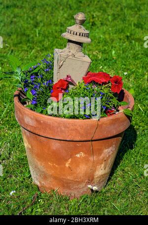 vieux pot en argile avec fleurs fleuries et lanterne poussiéreuse d'entraîneur Banque D'Images