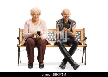 Femme âgée et punk assis sur un banc et utilisant des téléphones portables isolés sur fond blanc Banque D'Images