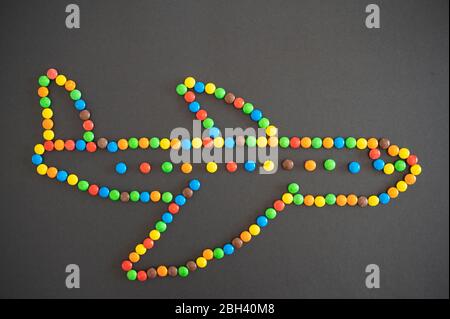 Les bonbons M&M qui forment un avion sur fond noir Banque D'Images