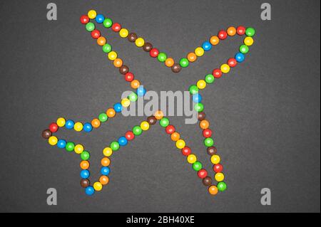 Les bonbons M&M qui forment un avion sur fond noir Banque D'Images