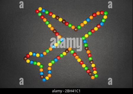 Les bonbons M&M qui forment un avion sur fond noir Banque D'Images