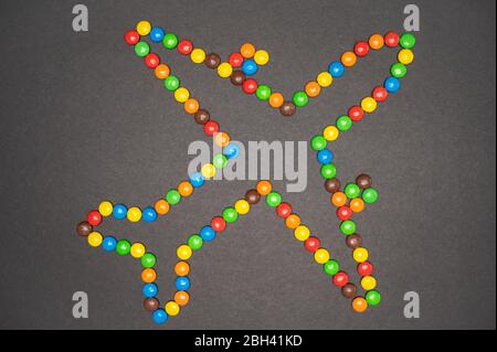 Les bonbons M&M qui forment un avion sur fond noir Banque D'Images