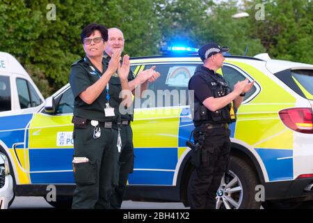 Hereford, Herefordshire, Royaume-Uni – jeudi 23 avril 2020 – les travailleurs et les policiers du NHS se tiennent à l'extérieur de l'hôpital du comté de Hereford à 20:00 pour se mettre en contact avec leurs collègues et les autres principaux travailleurs de la santé pour le cinquième jeudi consécutif depuis le début du verrouillage du Coronavirus Covid-19 - ils ont également chanté sur la chanson Vous ne marchez jamais seul. Les chiffres publiés aujourd'hui montrent que 18 738 personnes sont mortes à l'hôpital au Royaume-Uni en raison de la maladie de Covid-19. Photo Steven May / Alay Live News Banque D'Images