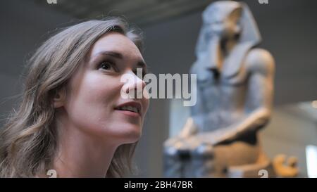 La jeune fille examine les expositions dans le musée. Banque D'Images