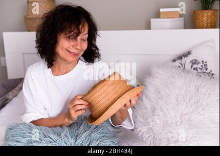Gros plan sur les femmes âgées positives pensionné s'asseoir se détendre à la maison regarder à distance fenêtre rêvant ou visualiser, sourire femme grand-mère perdu dans les pensées se souvenir bon. Période de quarantaine Banque D'Images