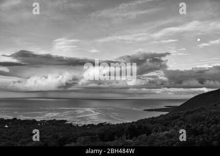 Lune noire et blanche et nuages au-dessus de la baie de Kealkakekua, sur l'île d'Hawaï. Banque D'Images