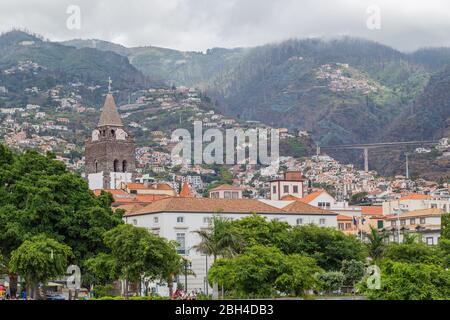 FUNCHAL, MADÈRE - 22 JUILLET 2018 : vue sur le centre-ville et les maisons sur les pentes des montagnes par une journée d'été nuageux Banque D'Images