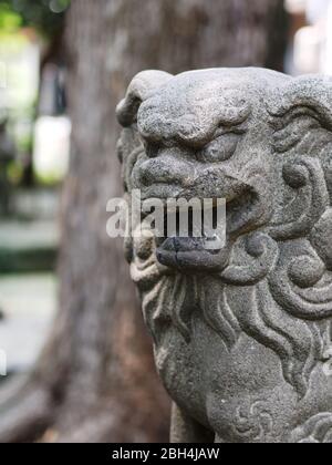 Gros plan de la statue du chien de garde-lion Komainu ou du tuteur japonais. Banque D'Images