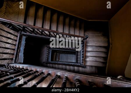 Antenne à angle élevé au-dessus de la vue en bas de la vieille spirale d'escalier vintage sinueuse à Lviv, Ukraine, Europe avec l'architecture de personne sombre bas-clé résumé patt Banque D'Images