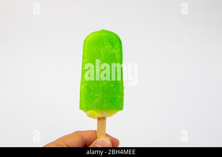Main de l'homme tenant la crème glacée Popsicle citron goût sur fond blanc. Banque D'Images