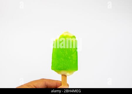 Main de l'homme tenant la crème glacée Popsicle citron goût sur fond blanc. Banque D'Images