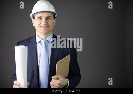 un constructeur positif dans un casque des vêtements formels peut dessiner en souriant