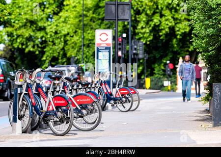 Londres, Royaume-Uni - 24 juin 2018: Quartier de Pimlico avec panneau pour de nombreux cycles Santander vélos rouges à louer garé dans le centre-ville à la rangée par rue latérale Banque D'Images