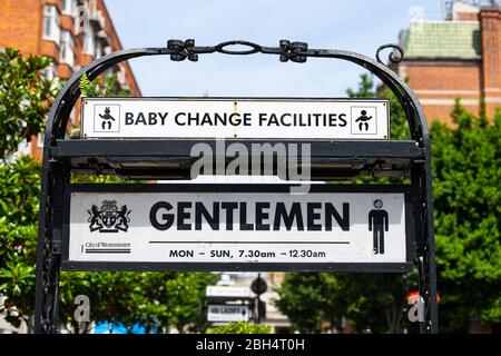 Londres, Royaume-Uni - 24 juin 2018 : rue Bayswater et panneau indiquant les installations de la station de changement de bébé et toilettes pour hommes en été c Banque D'Images