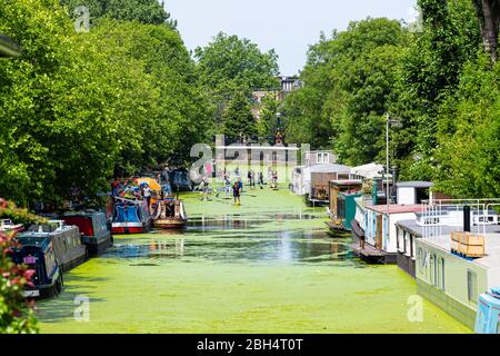 Londres, Royaume-Uni - 24 juin 2018 : quartier de Little Venice Italie bateaux de canal pendant la journée ensoleillée d'été et les gens sur stand up paddle board activité Banque D'Images