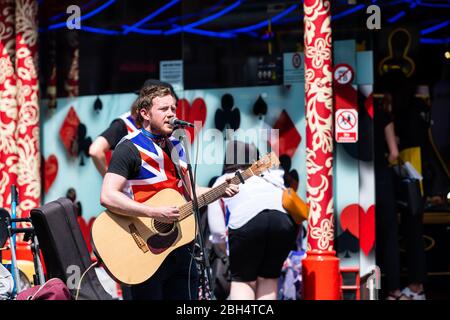 Londres, Royaume-Uni - 24 juin 2018 : la région de Piccadilly soho avec musicien patriotique jouant de la musique sur le chant de guitare dans le microphone avec un maillot Union Jack Flag Banque D'Images