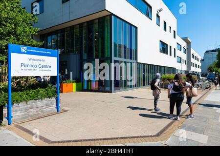 Londres, Royaume-Uni - 25 juin 2018 : trottoir de rue dans le quartier local avec panneau d'entrée pour Pimlico Center et étudiants en personne debout Banque D'Images