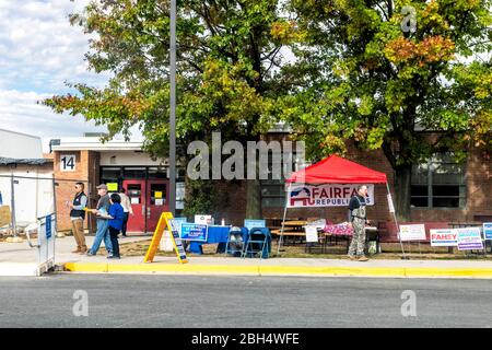 Herndon, États-Unis - 5 novembre 2019: Bureau de vote du lycée avec voie de trottoir et stand des Républicains de Fairfax avec des gens qui distribuent des bulletins de vote échantillons A Banque D'Images