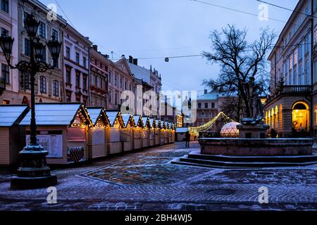 Lviv, Ukraine - 28 décembre 2019: Vieille ville marché fontaine d'eau carrée à Lvov avec éclairage de Noël d'hiver et vider rynok la nuit avec la neige Banque D'Images