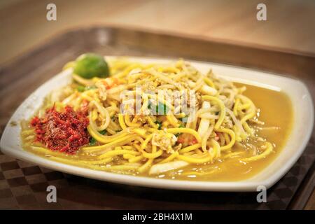 Cuisine de Singapour fruits de mer Hokkien Mee avec des crevettes géantes, calmar, porc et œufs frits avec des nouilles jaunes et vermicelles dans le bouillon de fruits de mer. Service Banque D'Images